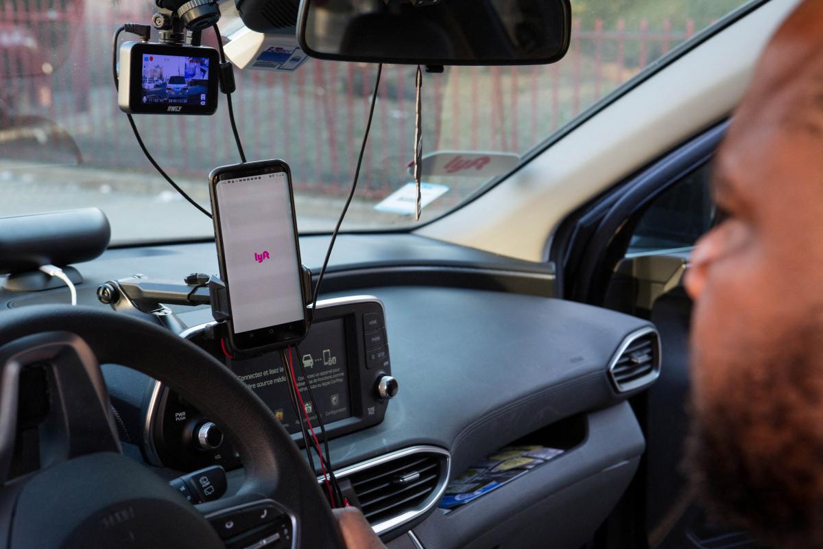 An Uber and Lyft driver sits in his car in New York City, New York, U.S., March 9, 2020. REUTERS/Joe Penney